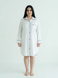 Woman wearing a white nightshirt on a plain background