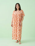 Woman wearing an orange floral dress against a light green background