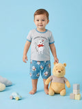 Child wearing a Winnie the Pooh-themed outfit with a plush toy on a blue background